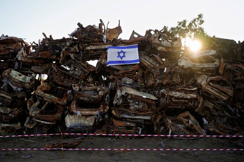Et israelsk flagg er plassert p vrakene av kjrety fra terrorangrepet i Israel 7. oktober.  Kjretyene ble samlet inn og plassert i et omrde nr Gaza-grensen etter angrepet, der 1200 mennesker ble drept og rundt 240 mennesker ble tatt som gisler.
 Foto: NTB/AP Photo/Ohad Zwigenberg