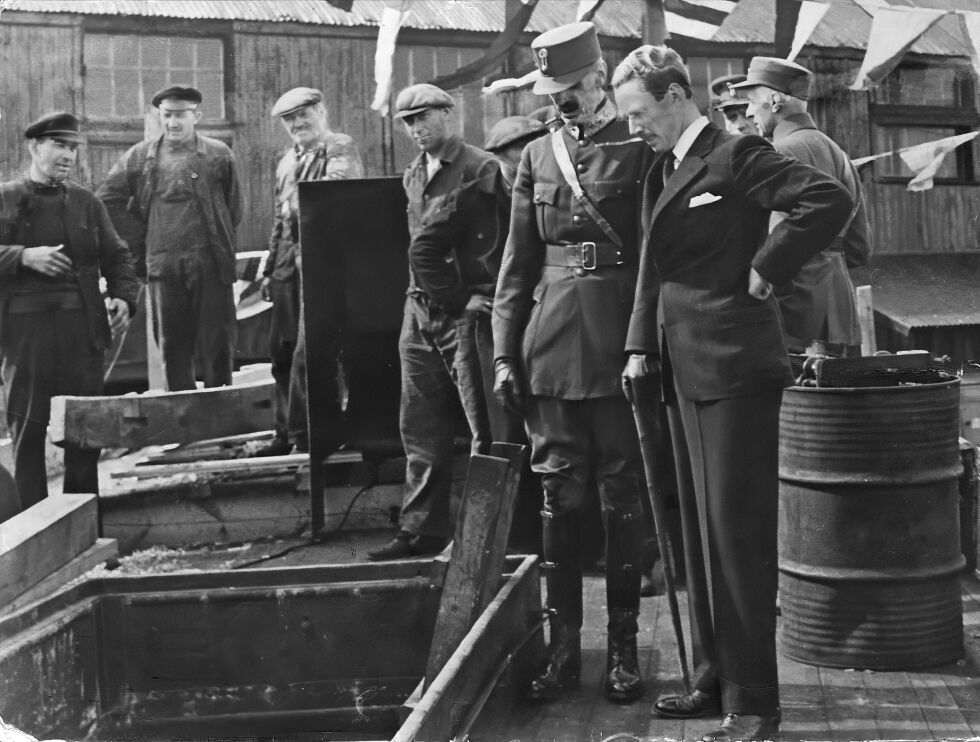 KONGEN: Kong Haakon 7. med følgje inspiserer skadar på «Lygrefjord» etter at skuta vart utsett for eit tysk angrep. Heilt til venstre Jens Lønøy, nummer fire frå venstre er Hermann Lønøy, bror til Jens. Biletet er tatt i Buckie, Skottland, der båten vart reparert.
Foto: Bilete utlånt av Steinar Lønøy.