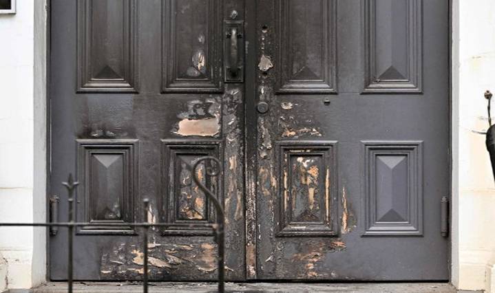 A photo shows the burnt front entrance of the East Melbourne Synagogue in Melbourne on July 6, 2025. A man suspected of setting fire to an Australian synagogue as worshippers ate dinner inside has been arrested and charged, police said on July 6. (Photo by William WEST / AFP)