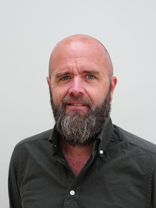 Mann smiler mot kameraet.