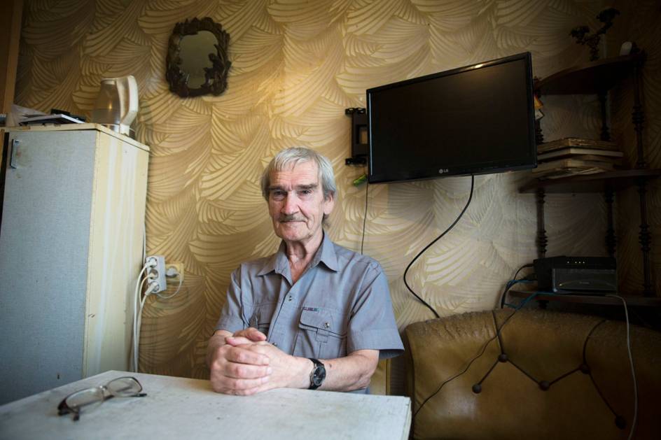 Bilde av Stanislav Petrov som sitter på kjøkkenet sitt.
