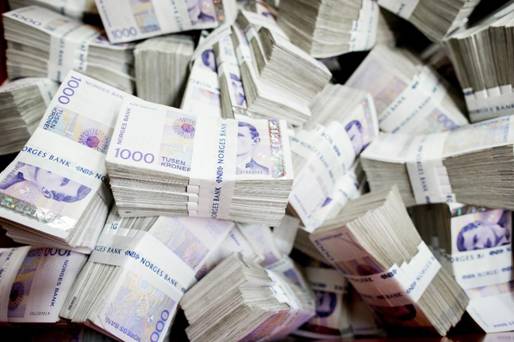 Snart borte: En solid bunke tusenlapper på vei inn i makuleringsmaskinen til Norges Bank. Snart kan norske kontanter være en saga blott.